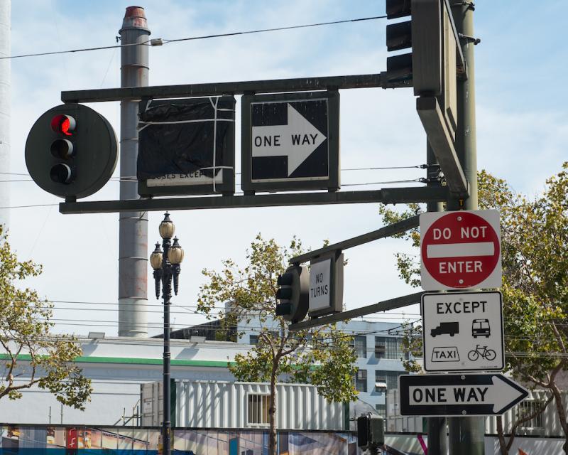 Traffic light and multiple signs, including One Way, Do Not Enter