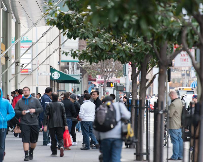 People walking along a busy sidewalk in SOMA