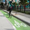8th Street after: bicyclist riding in a bikeway protected by a loading island.