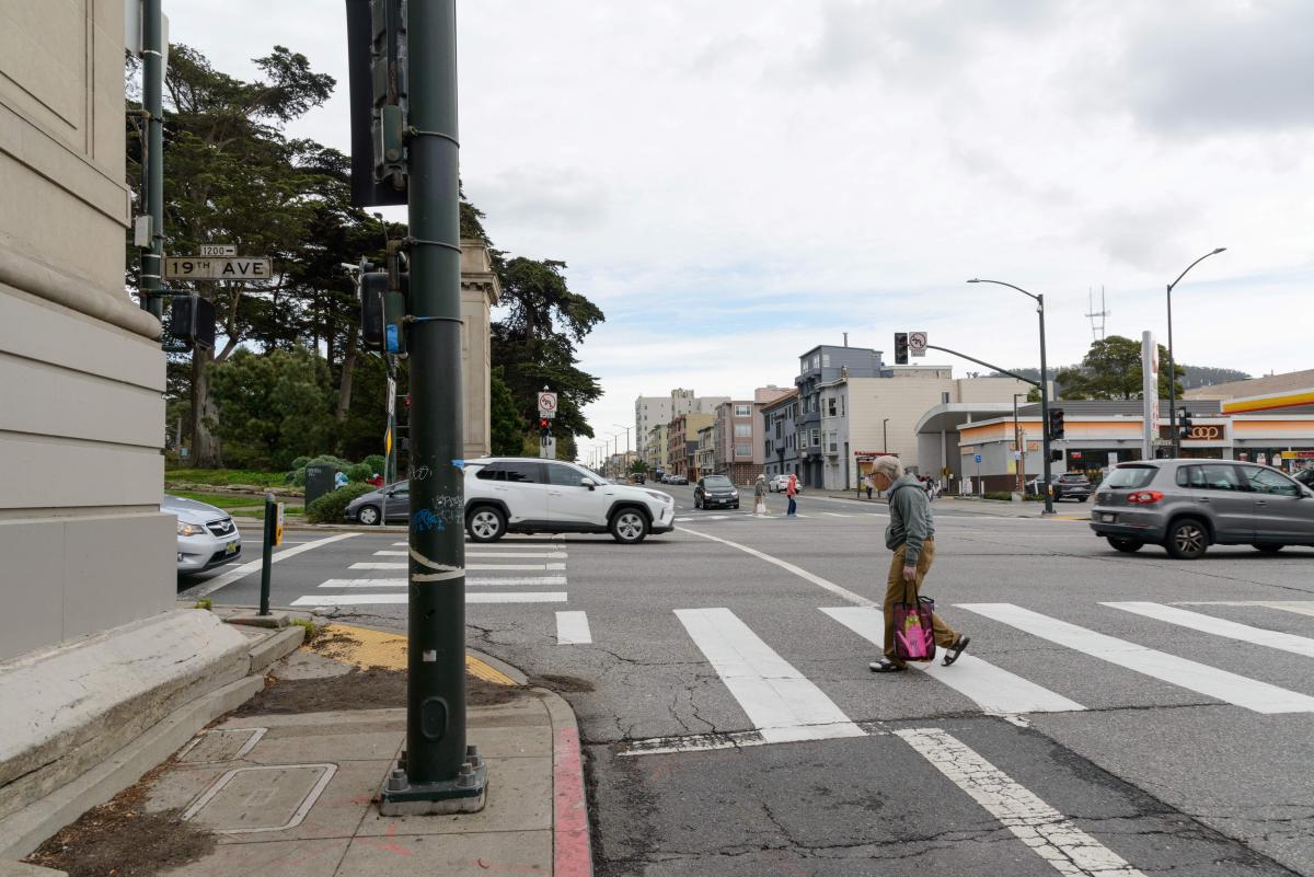 Person walks across the street at a major intersection near Golden Gate Park. Person walks across the street at a major intersection near Golden Gate Park.