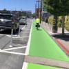 7th Street after: bicyclist riding in a protected bikeway with green paint