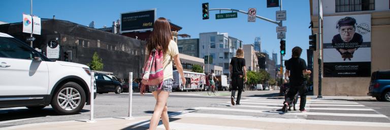 Photo of vehicle yielding to crossing pedestrians with no turn on red sign in background. 